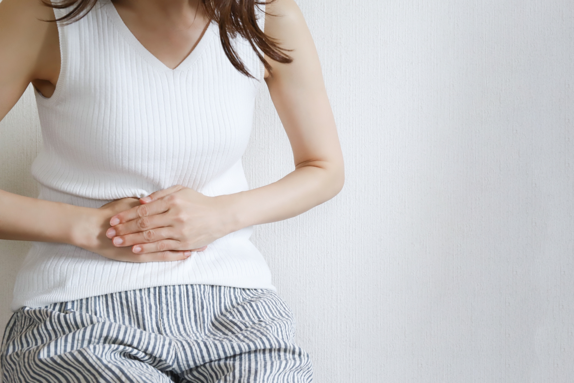 お腹を押さえる女性